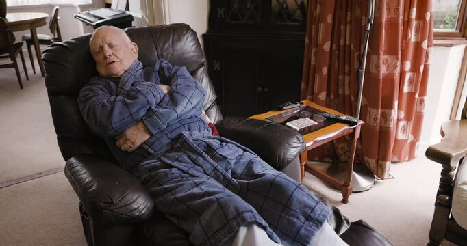 Sleep, rest and senior man on a sofa with a warm gown to take a nap in the living room of his house. Relax, insomnia and elderly guy in retirement sleeping or resting on a couch in the lounge at home