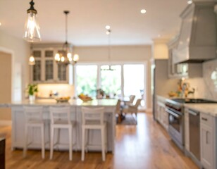 Blurred image of a bright, modern kitchen with island, white cabinets, hardwood floors, and large windows.