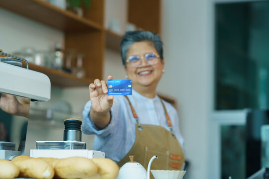 asian senior women show credit card, small business shop