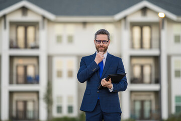 Real estate agent business man in suit hold holder clipboards outside. Hispanic Businessman....