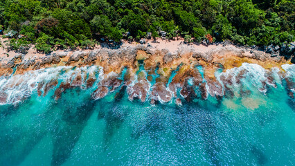 Scenic aerial of coastal reef and waves on rocks in turquoise water ideal tropical summer backdrop
