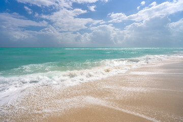 Summer beach shore. Colorful sea beach water. Warm ocean breeze. Summer sea beach. Sea background. Blue ocean. Sandy beach. Ocean waves. Summer seaside. Tropical coastline. Foamy wave splash.