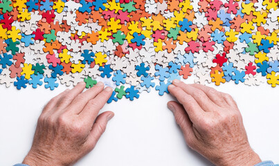 Hands Over Colorful Puzzle Pieces on White Background, Engaging in Problem Solving or Recreation, Visual Representation of Fun and Mind Challenge