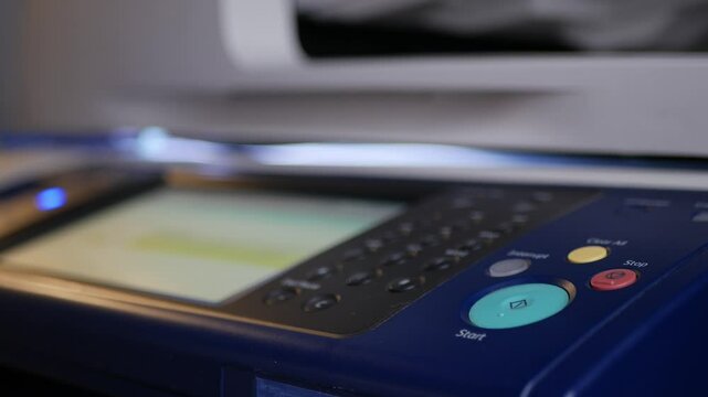 Close up hand office man press start button on panel to using the Office professional multi-function printer scanner for scanning document printing. a Copy machines