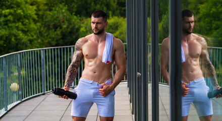 Obraz premium Muscular man lifting weights at gym. Handsome guy prepare to do exercises with dumbbell.