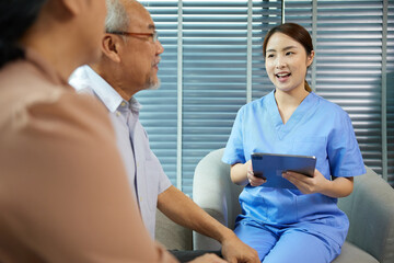 Obraz premium nurse or caregiver meeting and talking with about health with senior couple