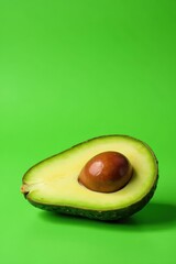 Juicy halved avocado with pit, vibrant green backdrop , leaf, ingredient, closeup