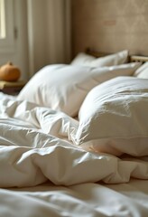 unmade bed with white sheets and pillows