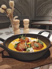 Cutlets in pumpkin sauce with feta cheese and herbs