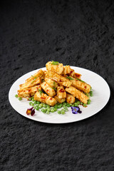 Professional Chinese food photography of peas and rice cakes on a plate on a rock textured table
