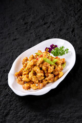 Professional Chinese food photography, deep fried pork on a rock textured table