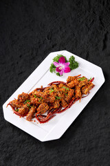 Professional Chinese food photography, spicy pork ribs on a rock textured table