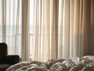 sheer curtains in a bedroom illuminated by warm morning sunlight