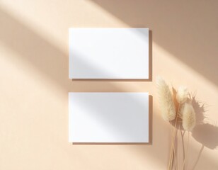 Two pristine white paper sheets lie flat on a soft beige background, showcasing their smooth texture and clean edges, inviting creativity and ideas.