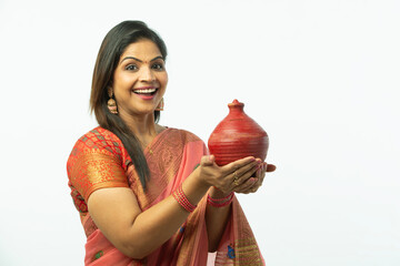 Smiling Attractive Beautiful Indian Woman showing piggy bank wearing traditional colorful saree in...