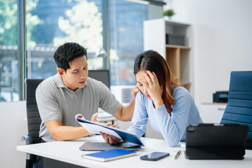 A stressed business team in shock after financial failure. Upset colleagues brainstorm solutions,...