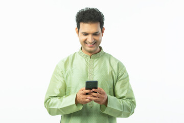 Portrait of Indian Young traditional man using mobile phone and wear mint ethnic kurta pajama isolated on a white background
