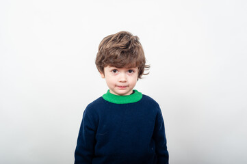 Child with brown hair wearing sweater stands still