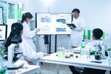 In the laboratory, a group of researchers meets to report their findings, discussing their work and preparing for future experiments, all focused on advancing science and health care.