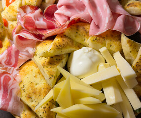 Mix of cheeses and cold cuts with slices of focaccia. Delicious food. Aperitif or starter. Traditional Italian food
