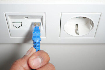 Connecting an ethernet cable to a wall socket in a modern setting