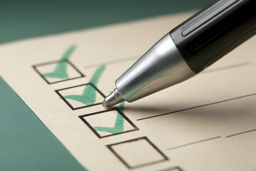 Checklist complete. Pen marks boxes on paper. Green ticks denote completed items. Light and shadow on surface