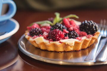 Delicious berry tart served on a plate in a cozy cafe setting
