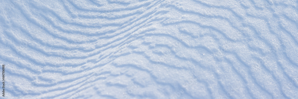 Wall mural beautiful winter background with snowy ground. natural snow texture. wind sculpted patterns on snow 