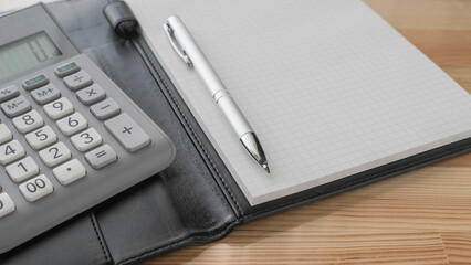 calculator , pen and  notebook on the desk