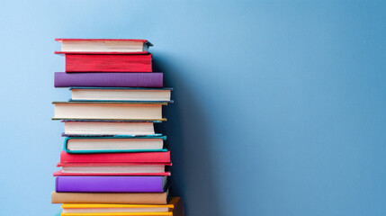 Stack of colorful books against a light blue background.  