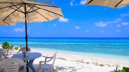 Summer tropical with white umbrella on the beach with  blue sky background