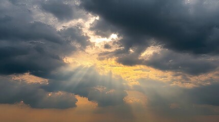 Obraz premium The sun breaks through storm clouds, creating a dramatic display of light and shadows, symbolizing the transition from turbulence to calm and the ever-changing power of nature.