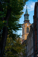 Obraz premium Szekesfehervar, Hungary - November 2, 2024: The Timeless Sentinel – Székesfehérvár’s church clock tower standing guard over the city
