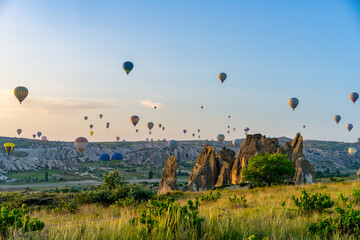 Hot air balloons flying over Cappadocia in Turkey at sunrise