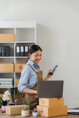 Woman Running Small Business with Laptop and Packages