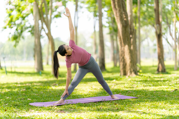 Fototapeta premium Woman Practicing Triangle Pose in Nature