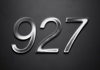 Chrome metal 3D number design of 927 on grey background.