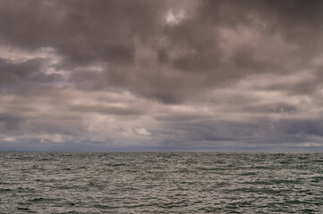 Dark storm clouds over ocean. Dramatic seascape. Clouds and rain flurry over sea.