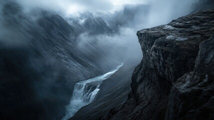 Moody mountain gorge with cascading waterfall