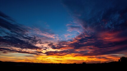 Obraz premium Vibrant Sunset Sky with Shifting Colors from Blue to Fiery Orange