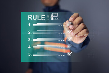Rule and regulation concept with safety staff tick checkmark on virtual screen to enforce workplace...