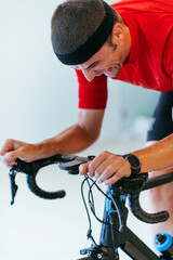 A triathlete riding a triathlon bike on a machine simulation in a modern living room. Training...