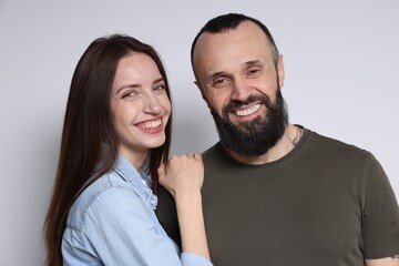 Fototapeta premium Portrait of happy daughter and father on light grey background
