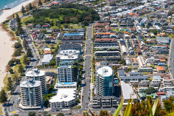 View from top of Mount Maunganui over high-rise commercial and apartment buildins below