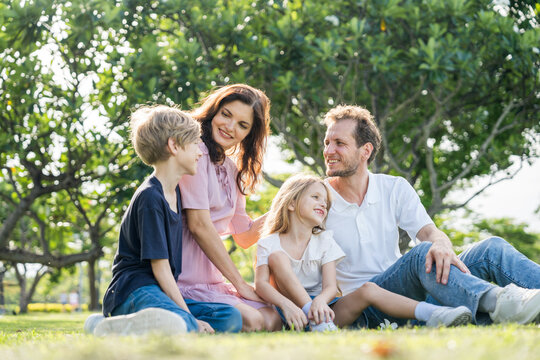 Happy family parent children having picnic outdoor activity. Enjoy happiness moment summer playing together including father mother son and daughter relaxing in the morning sunrise.