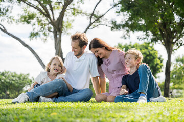 Fototapeta premium Happy family parent children having picnic outdoor activity. Enjoy happiness moment summer playing together including father mother son and daughter relaxing in the morning sunrise.