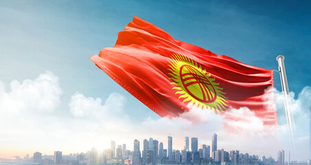 Kyrgyzstan national flag waving in the sky with cityscape. Kyrgyzstan national flag for...