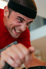 A triathlete riding a triathlon bike on a machine simulation in a modern living room. Training...