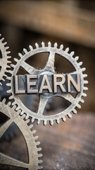 Mechanical gears with word LEARN prominently displayed, symbolizing education and knowledge. close up view highlights