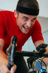 A triathlete riding a triathlon bike on a machine simulation in a modern living room. Training...